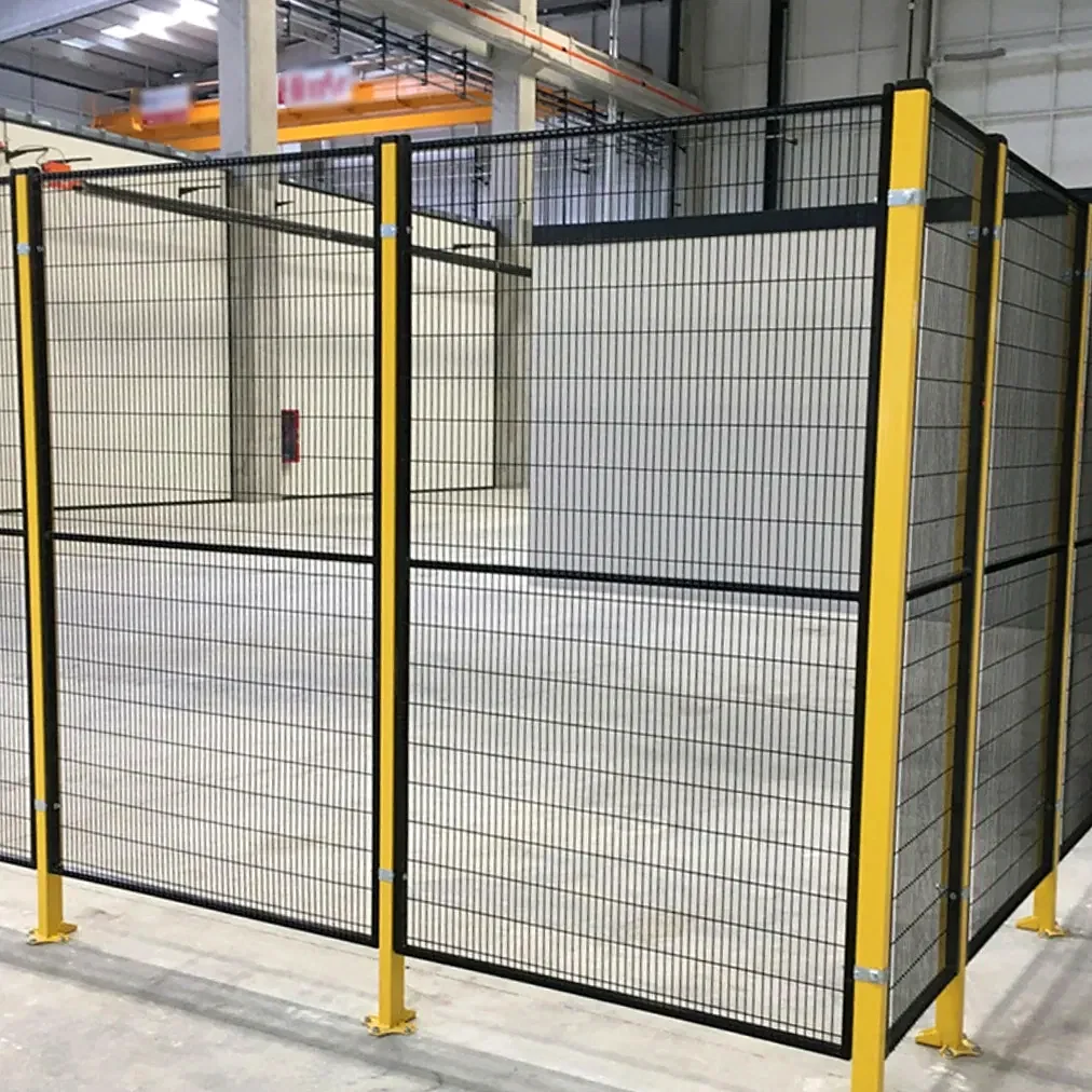 Black mesh fencing with yellow posts inside an industrial building.
